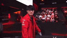 a man wearing glasses and a red jacket with a mercedes logo on it