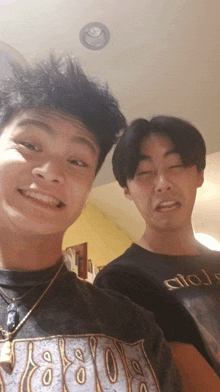 two young men posing for a picture one wearing a t-shirt that says circle