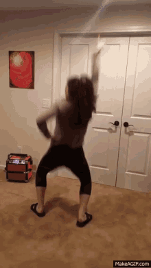 a woman is dancing in a room with a makeagif.com link in the bottom right corner
