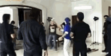 a group of people are standing in a room and one of them is wearing a shirt that says ' rbd ' on it