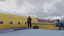 a man is standing in front of a yellow airplane that says adios airlines