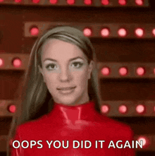 britney spears is wearing a red latex outfit and making a funny face .