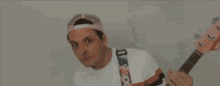 a man wearing a pink hat and a white sweater is making a funny face .