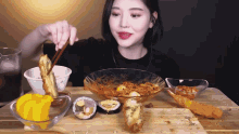 a woman is sitting at a table with a bowl of food and chopsticks
