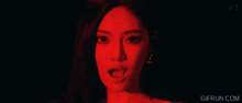 a woman in a red light with gifrun.com at the bottom of the screen