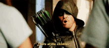a man in a hooded jacket is holding a bow and arrow .