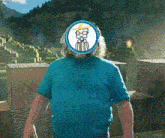 a man in a blue shirt has a picture of a man with glasses on his head