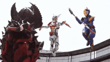a man in a blue suit is jumping in the air while holding a sword