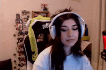 a girl wearing headphones is sitting in a chair in a room .