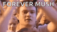 a man is standing in front of a crowd of people with the words `` forever mush '' written on the bottom .
