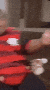 a fat man wearing a red and black striped shirt with the letter r on it .