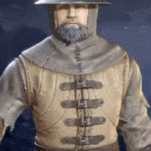 a man with a beard is wearing a hood and a hat .