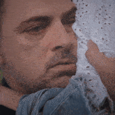 a close up of a man 's face with a woman holding his face