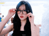 a woman wearing glasses and a black tank top with ive autumn written on the bottom