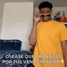 a man in a yellow shirt is wearing sunglasses and says osease que tranzitas por tus venas mi nero