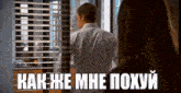 a man in a striped shirt stands in front of a window with the words " как же мне похуй " on the bottom right