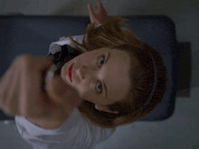 a woman is holding a candle in her hand and pointing at the camera