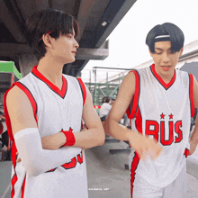 two basketball players are standing next to each other and one of their jerseys says bus