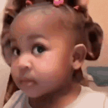 a little girl with curlers in her hair is making a face .