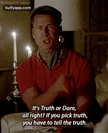a man is sitting at a table with candles and says it 's truth or dare .