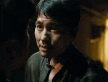 a man in a black jacket looks at another man