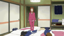 a girl in a pink jacket stands in a room