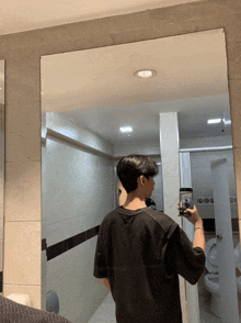 a man taking a picture of himself in a bathroom