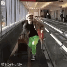 a man is walking down an escalator with a suitcase and a skateboard .