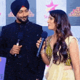 a man in a turban holds a microphone next to a woman in a yellow dress