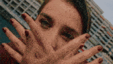 a close up of a woman covering her face with her hands
