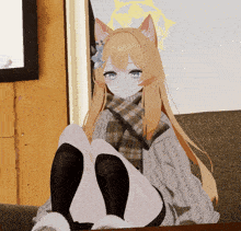 a girl with cat ears and a scarf around her neck sits on a couch