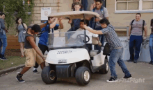 a group of people pushing a white golf cart that says security
