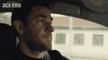 a man sitting in a car with the name jack ryan on the side