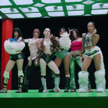a group of women are posing for a picture and one of them is wearing a pink top