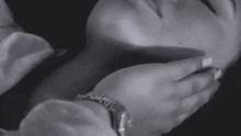 a black and white photo of a woman 's hands on her face