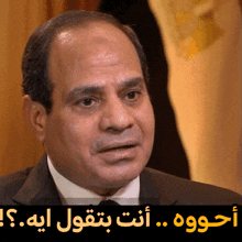 a close up of a man 's face with arabic writing above him