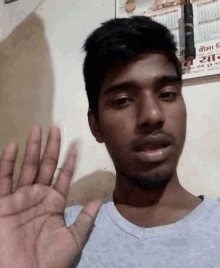 a man is waving his hand in front of a wall with a calendar on it that says ' a ' on it