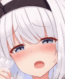 a girl with white hair and blue eyes is crying .