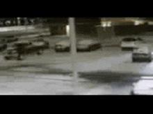 a blurred image of a parking lot with cars parked in it at night .