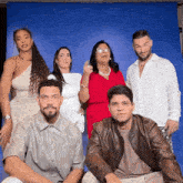 a group of people are posing for a picture in front of a blue backdrop