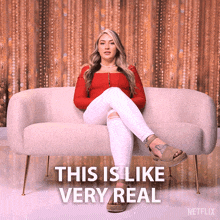 a woman sits on a couch with the words " this is like very real " written below her