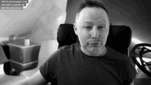 a man with a beard is sitting in a chair and looking at the camera