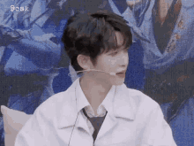 a young man wearing a white shirt and tie with a microphone on his ear .