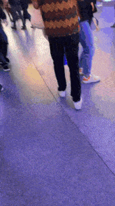 a group of people walking on a concrete floor