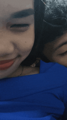 a close up of a woman 's face with a man behind her