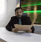 a man in a suit and tie is reading a piece of paper