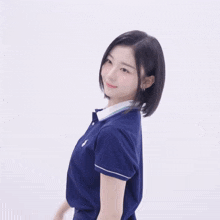 a woman wearing a blue polo shirt with a white collar