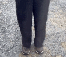 a person wearing black pants and white sneakers