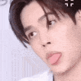 a close up of a young man sticking out his tongue .