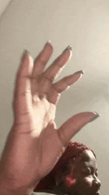 a close up of a woman 's hand reaching up towards the ceiling